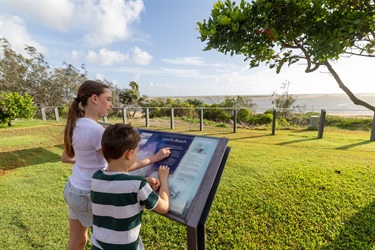 A young girl and boy reading the information sign on Alva at Alva Lookout.